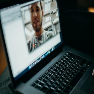 Close-up of a person engaged in a video call on a laptop indoors, showcasing modern technology.